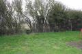 Gap in the hedge with the block on right hand side of path